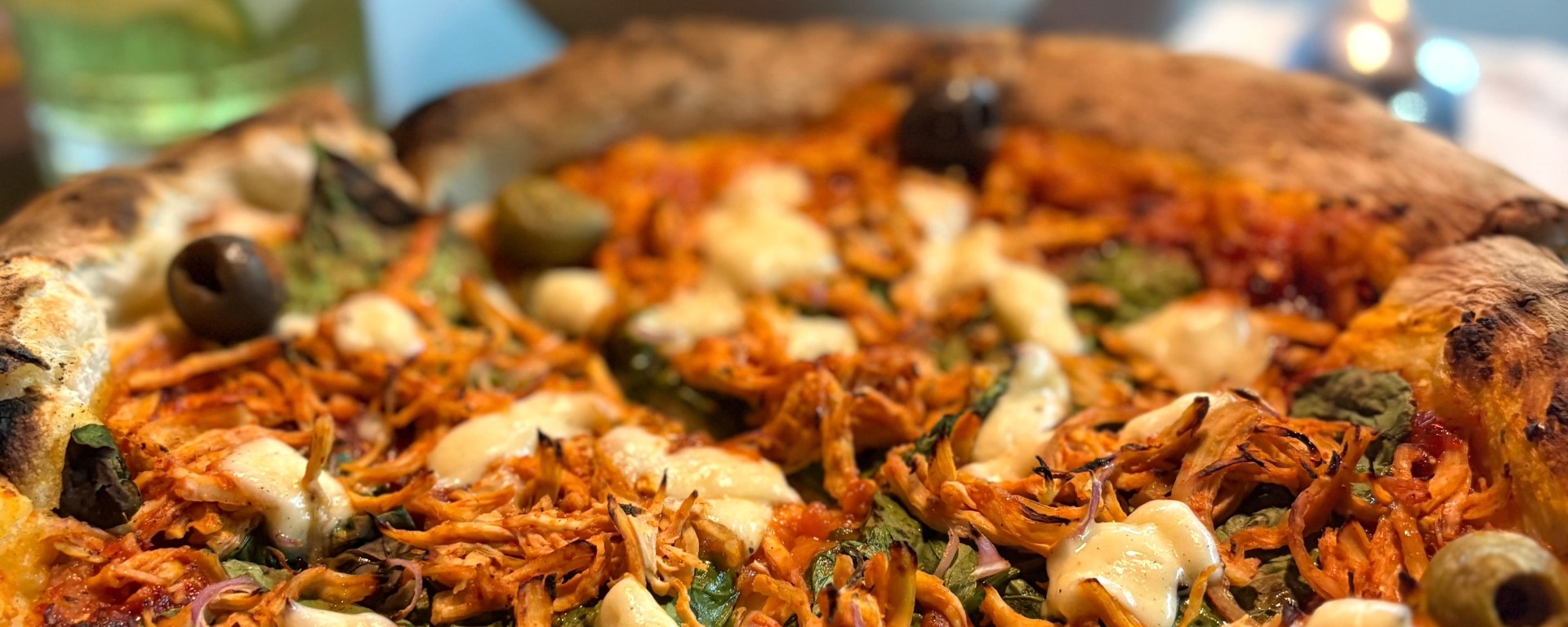Hand-rolled sourdough Sriracha Chicken Pizza topped with pulled chicken, buffalo mozzarella, caramelised onions, and spicy sriracha sauce at Melba Italian Eatery, Nashik